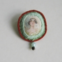 Art Deco hölgy cicával bross, Ékszer, óra, Bross, kitűző, Horgolt kitűző, középen vékony vászonra nyomott  képpel.Gyapjúval kitömve.
Gyöngyös fityegővel díszí..., Meska