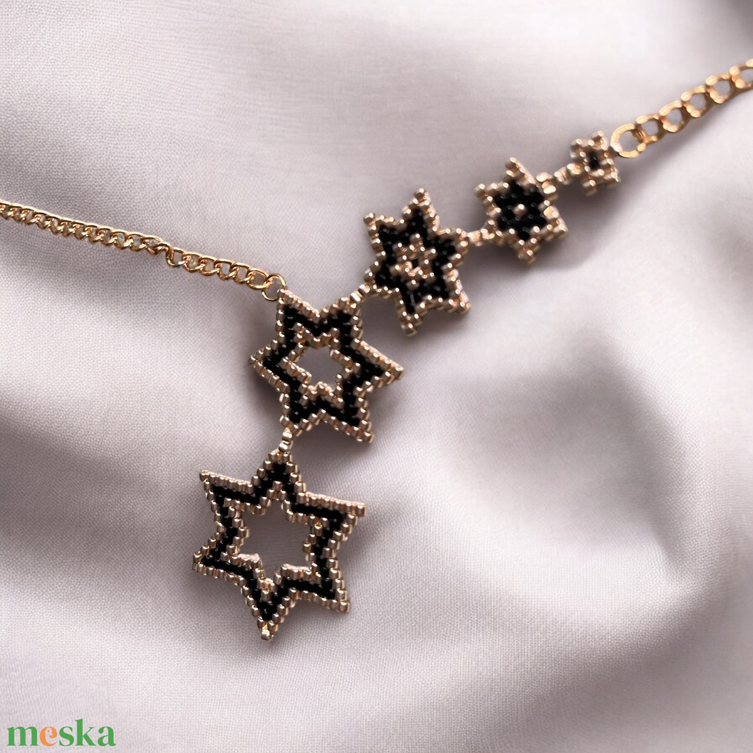 Aranyló Csillaghullás - kézzel gyöngyfűzött, elegáns nyaklánc, egyedi, növekvő csillag formák, időtlen fekete-arany szín - ékszer - nyaklánc - gyöngyös nyaklánc - Meska.hu