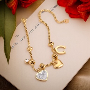 Elegáns aranyszínű nemesacél charm karkötő szív és patkó charmokkal - ékszer - karkötő - karkötő medállal - Meska.hu