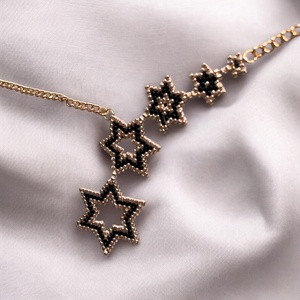 Aranyló Csillaghullás - kézzel gyöngyfűzött, elegáns nyaklánc, egyedi, növekvő csillag formák, időtlen fekete-arany szín - ékszer - nyaklánc - gyöngyös nyaklánc - Meska.hu