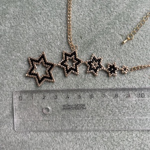 Aranyló Csillaghullás - kézzel gyöngyfűzött, elegáns nyaklánc, egyedi, növekvő csillag formák, időtlen fekete-arany szín - ékszer - nyaklánc - gyöngyös nyaklánc - Meska.hu